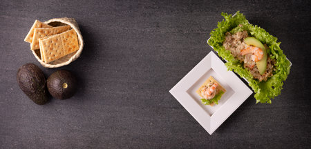 Tuna salad with avocado and canape with shrimp. Delicious healthy and easy recipe to prepare snack. Panoramic table topview.の写真素材