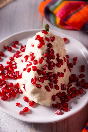 Chiles en Nogada, Typical dish from Mexico. Prepared with poblano chili stuffed with meat and fruits and topped with a walnut sauce. Named as the quintessential Mexican dish for national holidays.の写真素材