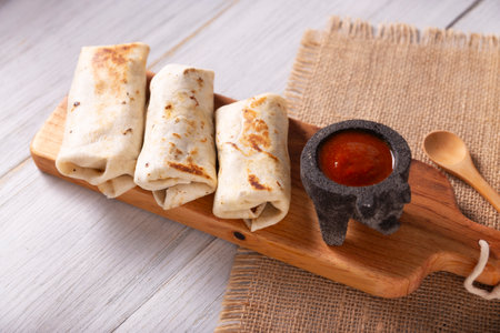 Burritos. Wrapped wheat flour tortilla, can be filled with various ingredients such as scrambled eggs or minced meat, beans and vegetables, a very popular dish in Mexico and the southern USA.の写真素材