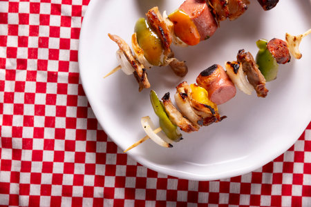Homemade Skewers with meat and grilled vegetables served on a rustic wooden board, also known as brochettes, alambre, chuzo or pincho. Table topview. Closeup view.の写真素材