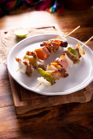 Homemade Skewers with meat and grilled vegetables served on a rustic wooden board, also known as brochettes, alambre, chuzo or pincho.の写真素材
