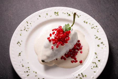 Chile en Nogada, Typical dish from Mexico. Prepared with poblano chili stuffed with meat and fruits and topped with a walnut sauce. Named as the quintessential Mexican dish for national holidays.の写真素材