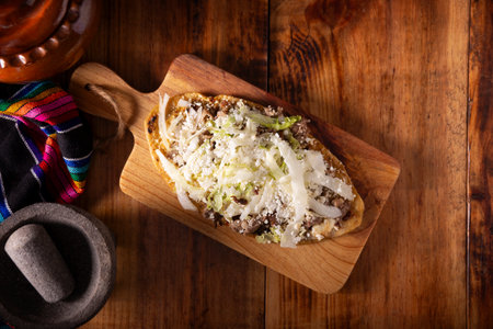 Huarache (food). Typical Mexican oval-shaped dish, made with corn dough and beans, commonly covered with lettuce, cheese, sauce and some protein such as steak, rib or egg.の写真素材