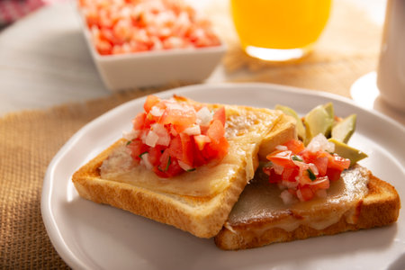 Breakfast toast with refried beans, avocado, melted cheese and Mexican pico de gallo sauce. Easy and healthy homemade recipe that can be made in the oven, frying pan or air fryer.の写真素材