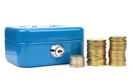 Cash box with lock  and stacked coinsの写真素材