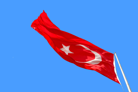 Waving Turkish flag on blue background