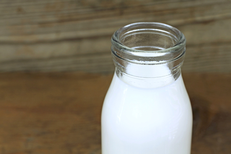 Milk and old style bottle on wood tableの写真素材