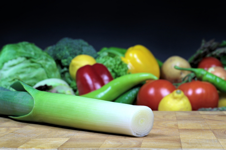 Leek on a chopping board and vegetablesの写真素材