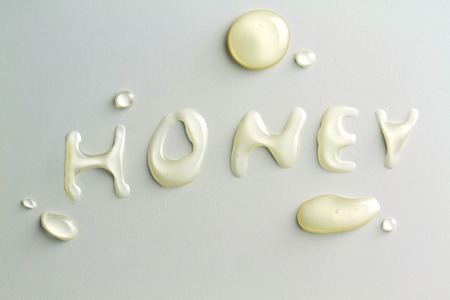 Honey drops and "HONEY" text with honeyの写真素材