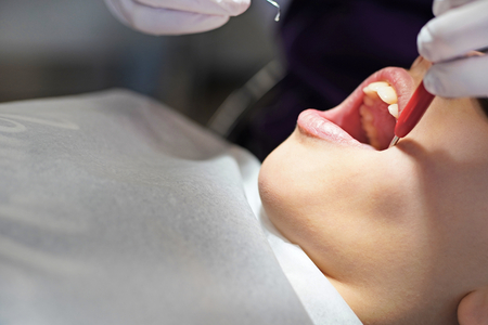 Dentist examining little boy's teeth in clinic
