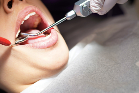 Dentist examining little boy's teeth in clinic