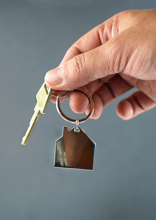 Handing over key with house shape key ring.の写真素材