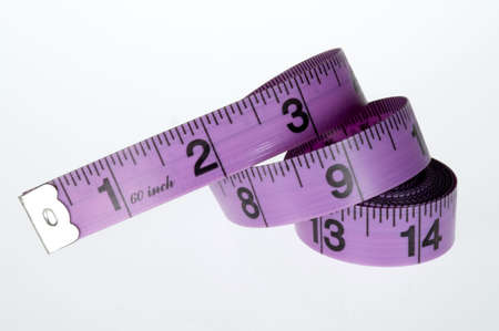 Measuring tape, purple and black, for sewing uncoiled on a white background.の写真素材