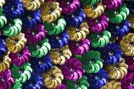 Close shot of green, gold, blue and fuschia sequin flowers create a vibrant background.の写真素材