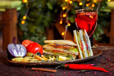 Sandwich with red fish on a plate with vegetables and a glass of mulled wineの写真素材
