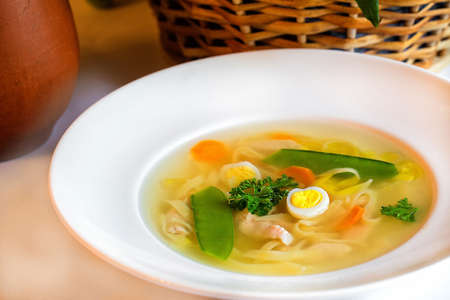 Chicken soup with noodles and quail eggの写真素材