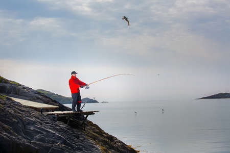 Man fisherman is fishing from the shore. In the spinning handsの写真素材