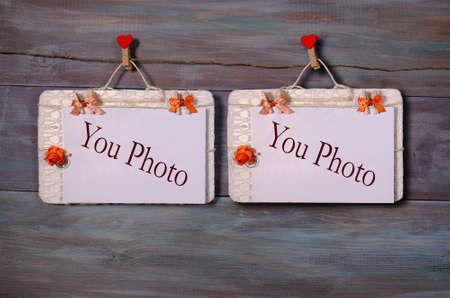 two photo paper attach to rope with clothes pins on wooden backgroundの写真素材