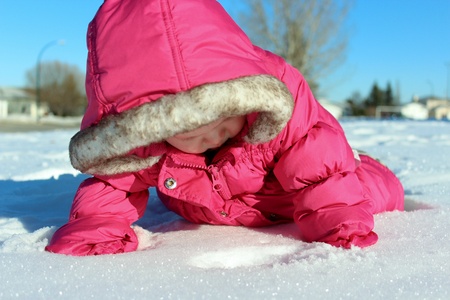 Adorable baby playing in snowの写真素材