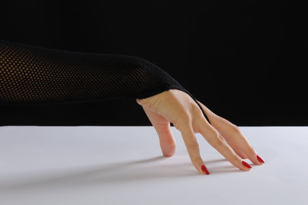 Female hands in black tights on a black background. studio shot.の写真素材