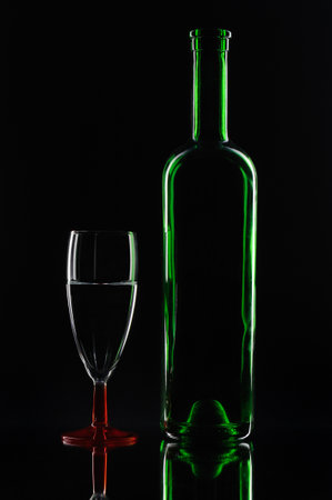 bottle and glass of wine on a black background with reflection.の写真素材