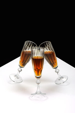 Two glasses of champagne on a white table against a black background.の写真素材