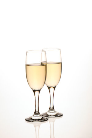 Two glasses of white wine isolated on a white background with reflection.の写真素材