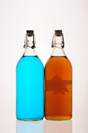 Two bottles of brandy with a blue and yellow star isolated on white backgroundの写真素材