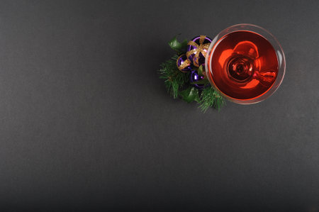 Red wine in a glass on a black background with christmas decorationの写真素材