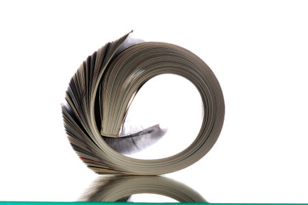 magazine rolled up on white background with reflection and copyspaceの写真素材