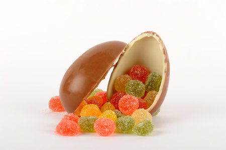 Colorful candies in chocolate egg shell isolated on white background.の写真素材