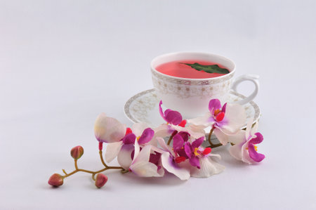 Cup of herbal tea with orchid flowers on a white background.の写真素材