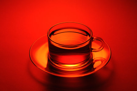 Transparent herbal tea cup of tea on a red background. close-up.の写真素材