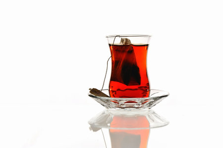 tea in a glass on a white background with reflection and shadowの写真素材