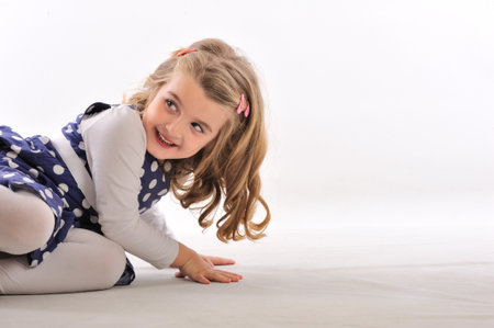 Cute little girl playing on the floor, isolated on white backgroundの写真素材