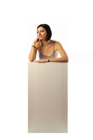 Young woman standing behind a blank board, isolated on white background.の写真素材