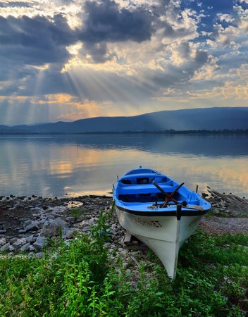 Sunset over a small fishing boat on the shore of Lake Ulubat, Golyazi, Bursa, Turkeyの写真素材
