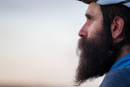 Young caucasian bearded man wearing a bike helmetの写真素材