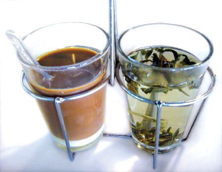 A popular traditional asian drink of coffee with condense milk and local tea to wash down the strong aftertaste of the coffeeの写真素材