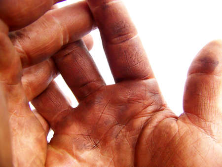 Detailed image of two hands darkened with grease, fingers interlaced, on white background.  Horizontal orientation.の写真素材