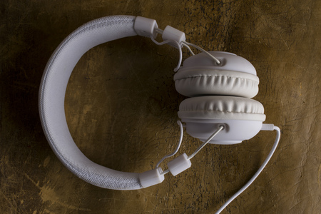 Isolated modern white headphone on a vintage leather background.の写真素材