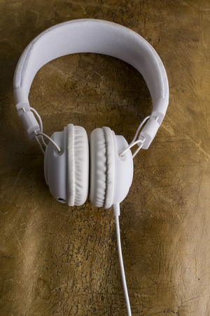 Isolated modern white headphone on a vintage leather background.の写真素材