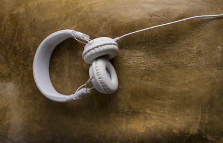 Isolated modern white headphone on a vintage leather background.の写真素材