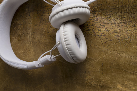 Isolated modern white headphone on a vintage leather background.の写真素材