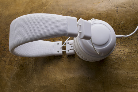 Isolated modern white headphone on a vintage leather background.の写真素材