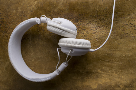 Isolated modern white headphone on a vintage leather background.の写真素材