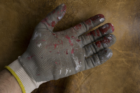 worn worker's gloves in a brown leather background.