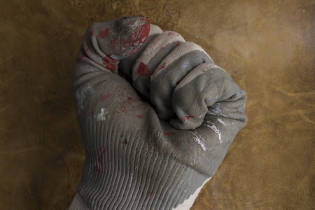 worn worker's gloves in a brown leather background.の写真素材