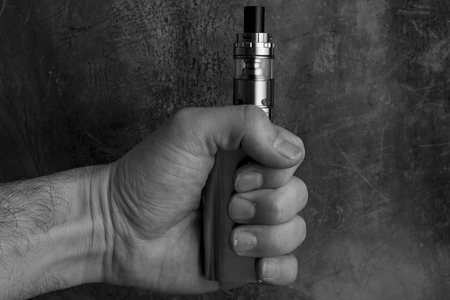 hand holding an electronic cigarette vaping device. in black and whiteの写真素材