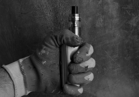 holding an electronic cigarette or vaping device by worker's hand. in black and whiteの写真素材
